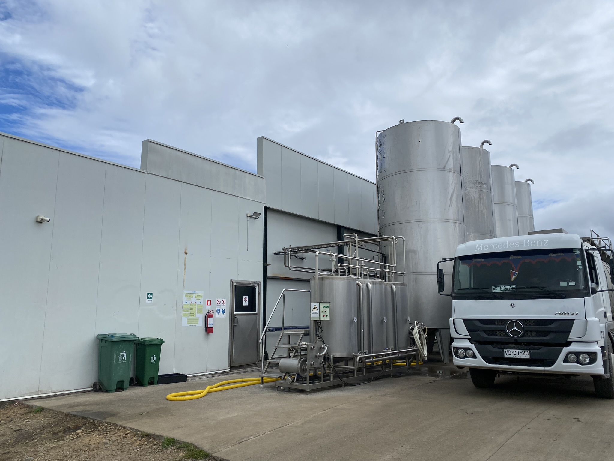 Camión cisterna junto a los silos y equipos de recepción de leche de la planta